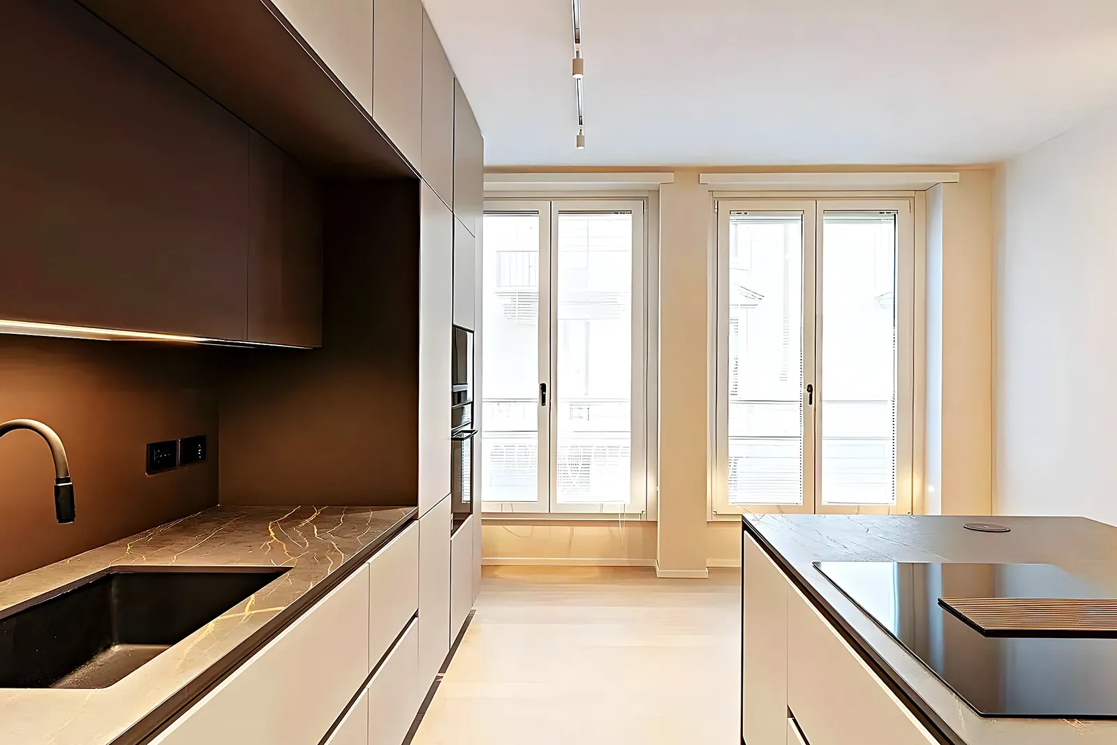 Kitchen with an island and tall brass-framed windows in a Vilanova i la Geltrú renovation