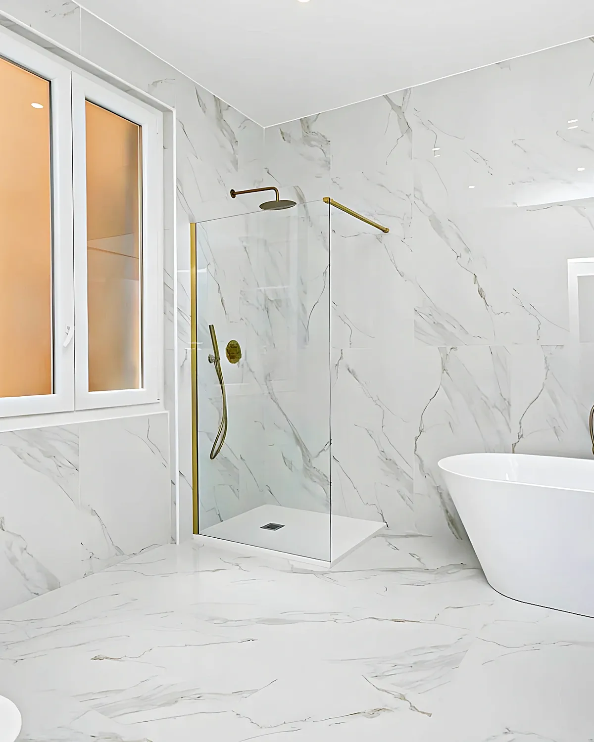 Bathroom with freestanding bathtub, calacatta marble and brass fittings in a Ribes Roges house, Vilanova