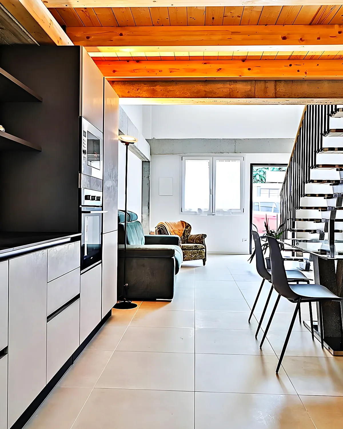 White and black kitchen with the duplex staircase behind, Molí de Vent neighbourhood, Vilanova