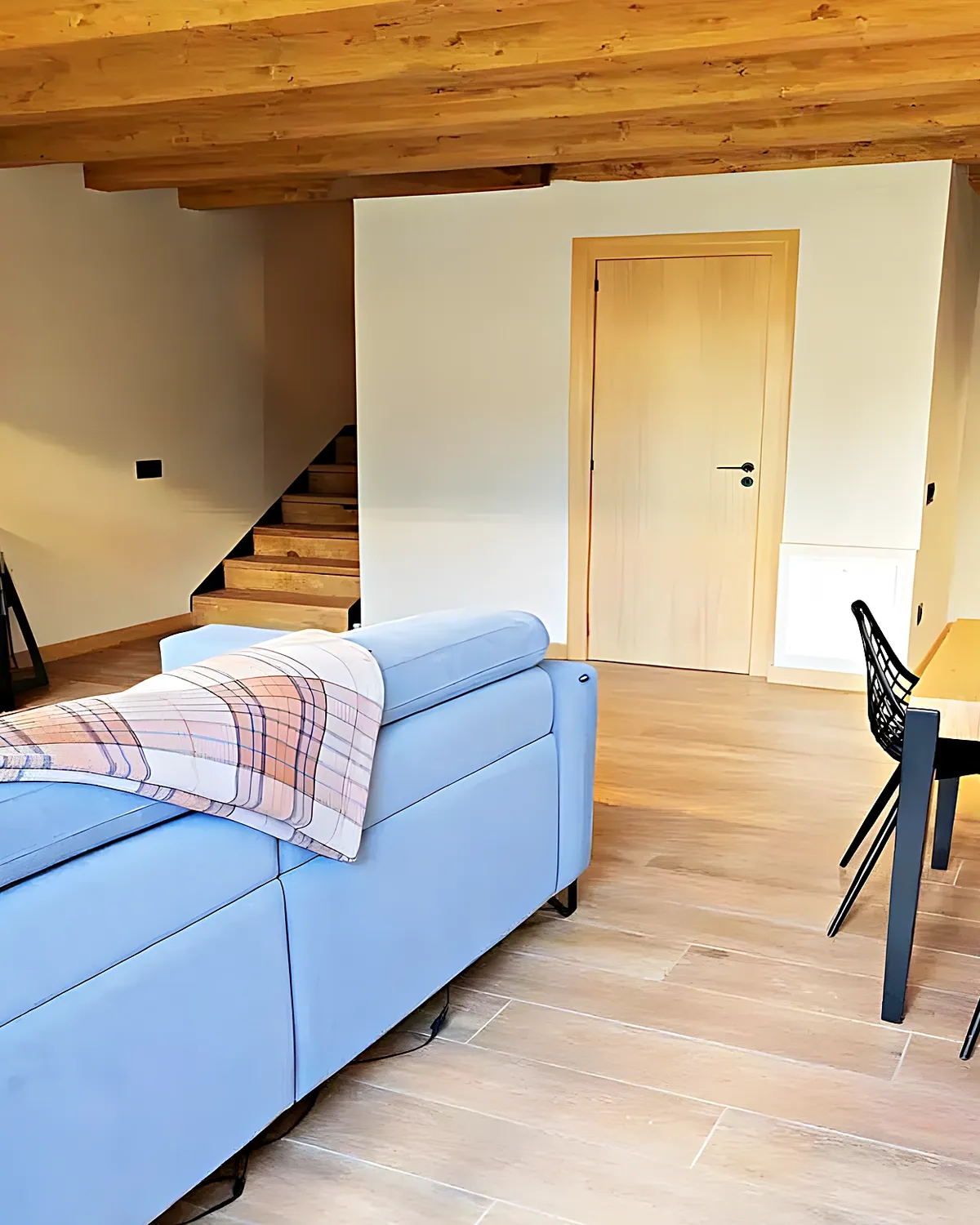 Living room with a wood-burning fireplace and wooden dining table in a Cubelles home renovated for year-round living