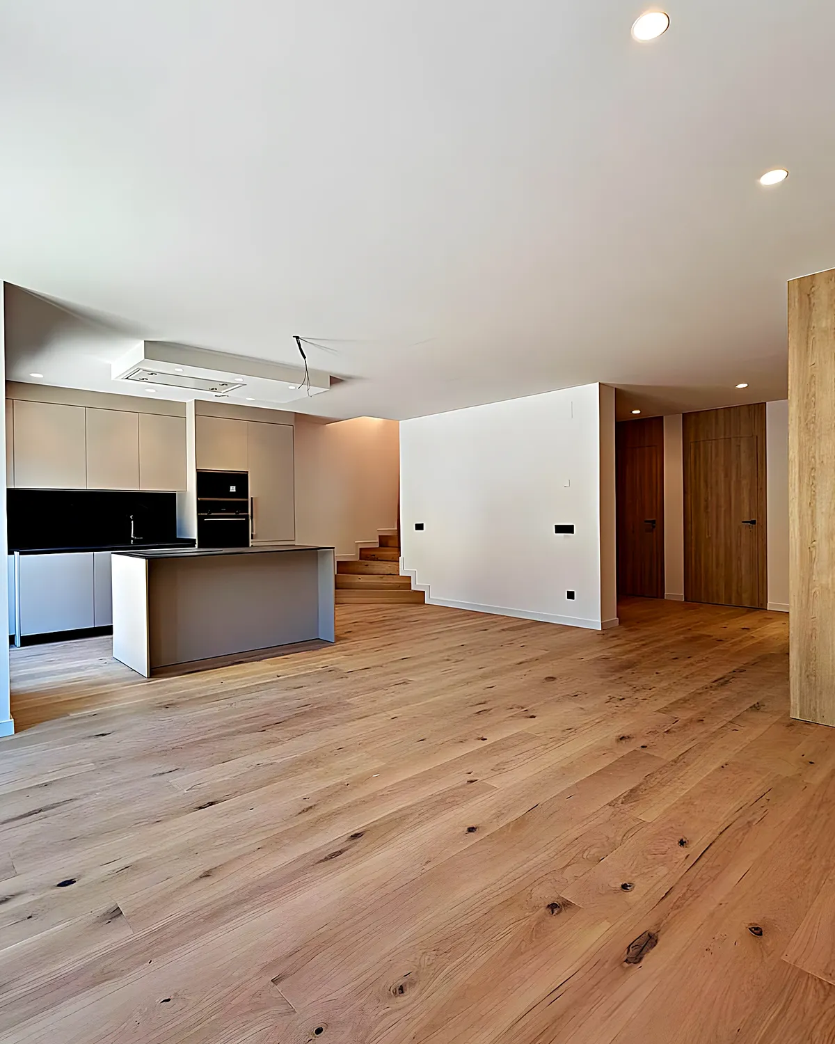 Living room with an open kitchen and light-wood joinery after a full renovation in Vilanova i la Geltrú