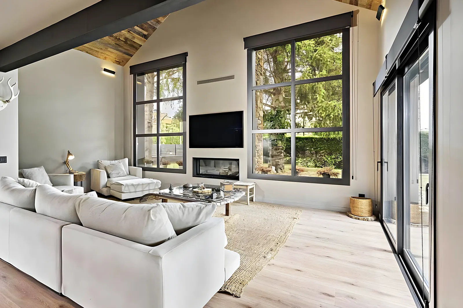 Renovated living room with black-framed windows and a fireplace, work by Reformas Vilanoví